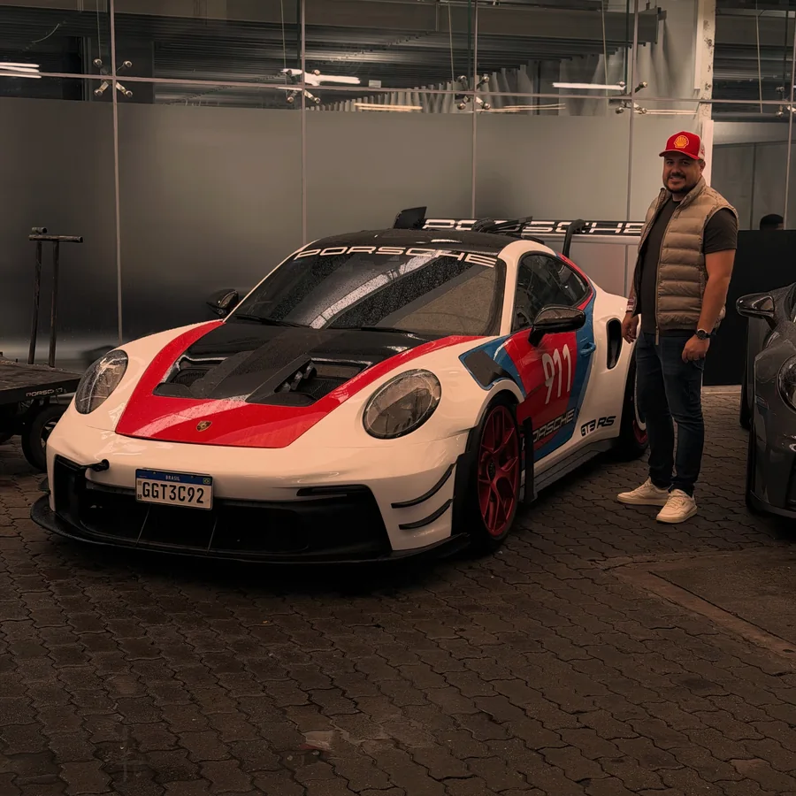 Rafael Tostes ao lado de um carro de competição Porsche