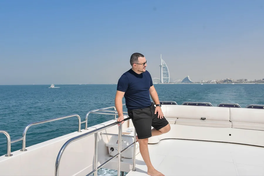 Rafael Tostes em embarcação com a cidade ao fundo